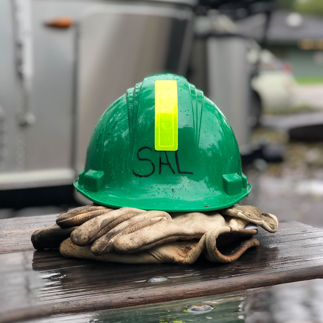 Green hard hat and gloves on table